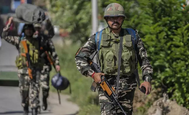 Indian paramilitary soldiers arrive to guard outside the venue for distribution of election material, in Pulwama, south of Srinagar, Indian controlled Kashmir, Tuesday, Sept. 17, 2024. (AP Photo/Mukhtar Khan)