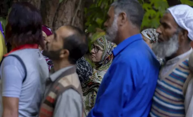 People queue up at a polling booth to cast their vote in Naira, south of Srinagar, Indian controlled Kashmir, Wednesday, Sept. 18, 2024. (AP Photo/Dar Yasin)