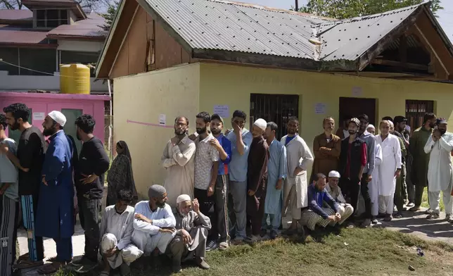 People queue up at a polling booth to cast their vote in Bellow, south of Srinagar, Indian controlled Kashmir, Wednesday, Sept. 18, 2024. (AP Photo/Dar Yasin)