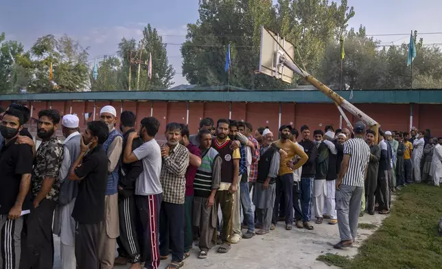 Kashmiri people queue up at a polling booth to cast their vote during the second phase of the assembly election in the outskirts of Srinagar, Indian controlled Kashmir, Wednesday, Sept. 25, 2024. (AP Photo/Dar Yasin)