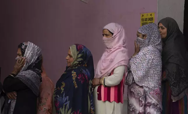 Kashmiri women queue up at a polling booth to cast their vote during the second phase of the assembly election in the outskirts of Srinagar, Indian controlled Kashmir, Wednesday, Sept. 25, 2024. (AP Photo/Dar Yasin)