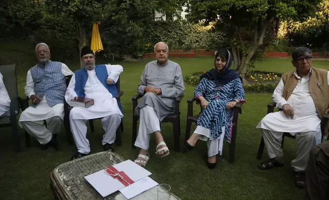 National Conference (NC) President Farooq Abdullah, center, Peoples Democratic Party (PDP) leader Mehbooba Mufti, second right, and other leaders sit during an all parties meeting on restoration of the special status that was stripped last year from Indian-administered Kashmir, in Srinagar, India. (AP Photo/Mukhtar Khan, File)