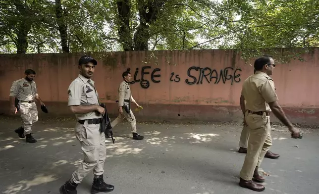 Indian policemen patrol as they guard near a venue for distribution of election material, ahead of the second phase of voting for choosing a local government in Indian-controlled Kashmir, in Srinagar, Tuesday, Sept. 24 , 2024. (AP Photo/Mukhtar Khan)