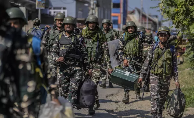 Indian paramilitary soldiers arrive to guard outside the venue for distribution of election material, in Pulwama south of Srinagar, Indian controlled Kashmir, Tuesday, Sept 17, 2024. (AP Photo/Mukhtar Khan)