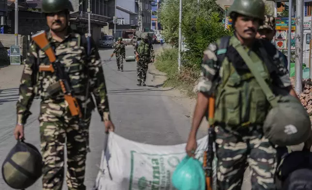 Indian paramilitary soldiers arrive to guard outside the venue for distribution of election material, in Pulwama, south of Srinagar, Indian controlled Kashmir, Tuesday, Sept. 17, 2024. (AP Photo/Mukhtar Khan)