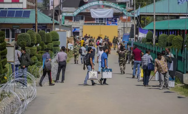 Polling officials carry electronic voting machines and other election material to a venue for distribution, in Pulwama south of Srinagar, Indian controlled Kashmir, Tuesday, Sept. 17, 2024. (AP Photo/Mukhtar Khan)