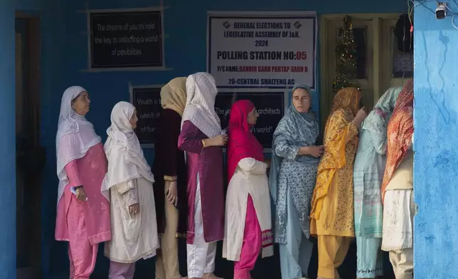 Kashmiri women queue up at a polling booth to cast their vote during the second phase of the assembly election in the outskirts of Srinagar, Indian controlled Kashmir, Wednesday, Sept. 25, 2024. (AP Photo/Dar Yasin)