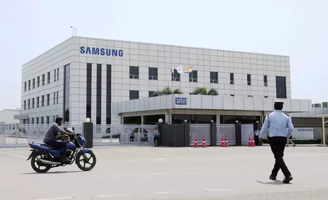 A motorcyclist rides past Samsung company plant in Sriperumbudur, on the outskirts of Chennai, India, Tuesday, Sept. 24, 2024. (AP Photo/Mahesh Kumar A.)