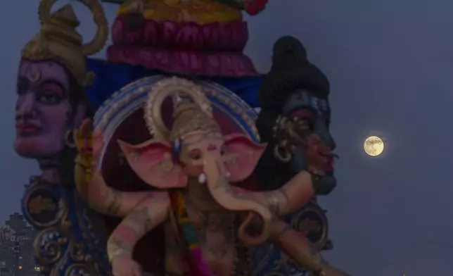 The Supermoon rises behind a giant idol of elephant-headed Hindu god Ganesha, in the Arabian Sea, marking the end of the 10-day long Ganesh Chaturthi festival in Mumbai, India, Tuesday, Sept. 17, 2024. (AP Photo/Rafiq Maqbool)