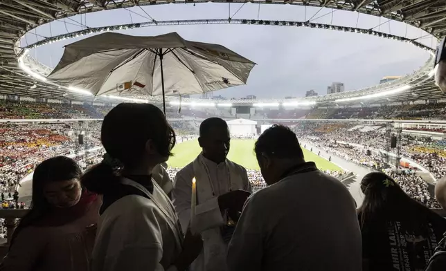 A priest gives Holy Communion to the faithful during a holy mass led by Pope Francis at the Gelora Bung Karno Stadium, in Jakarta, Thursday, Sept. 5, 2024. (Yasuyoshi Chiba/Pool Photo via AP)