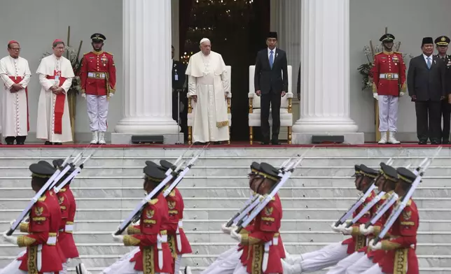 Pope Francis, top centre left, Indonesian President Joko Widodo, top centre right, and Indonesian President-elect Prabowo Subianto, top second right, review honor guards during a welcome ceremony at the Istana Merdeka Presidential Palace in Jakarta Wednesday, Sept. 4, 2024. (Adi Weda/Pool Photo via AP)