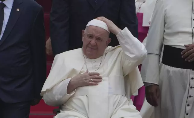 Pope Francis on his wheelchair, holds his cap upon arrival during an official welcoming ceremony at Soekarno-Hatta International Airport in Tangerang on the outskirts of Jakarta, Indonesia, Tuesday, Sept. 3, 2024. (AP Photo/Achmad Ibrahim)