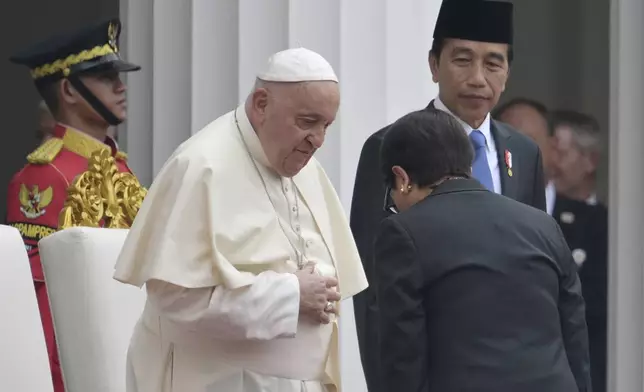 Pope Francis, center left, meets Indonesia's Foreign Minister Retno Marsudi, foreground, as Indonesia's President Joko Widodo, center right, looks on during a ceremonial welcome at the Presidential Palace in Jakarta Wednesday, Sept. 4, 2024. (Bay Ismoyo/Pool Photo via AP)