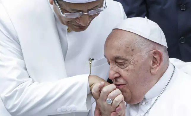 Pope Francis, right, kisses the right hand of the Grand Imam of Istiqlal Mosque Nasaruddin Umar after an interreligious meeting with religious leaders at the Istiqlal Mosque in Jakarta, Thursday, Sept. 5, 2024. (Aditya Aji /Pool Photo via AP)