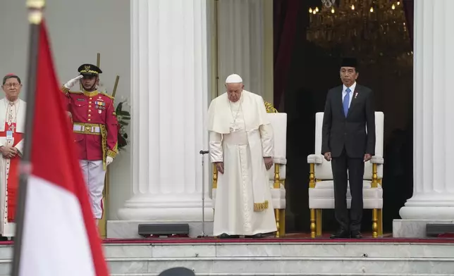 Indonesian President Joko Widodo, right, receives Pope Francis, center, at Istana Merdeka Presidential Palace in Jakarta, Wednesday, Sept. 4, 2024. Pope Francis is opening his visit to Indonesia with a packed first day Wednesday, meeting political and religious leaders and setting a rigorous pace for an 11-day, four-nation trip through tropical Asia and Oceania that will test his stamina and health. (AP Photo/Gregorio Borgia)