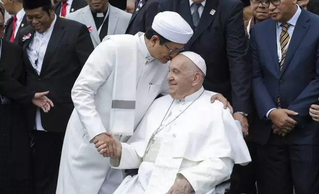 Pope Francis, right, and the Grand Imam of Istiqlal Mosque Nasaruddin Umar shakes hands during a family photo following an interreligious meeting with religious leaders at the Istiqlal Mosque in Jakarta, Thursday, Sept. 5, 2024. (Aditya Aji /Pool Photo via AP)