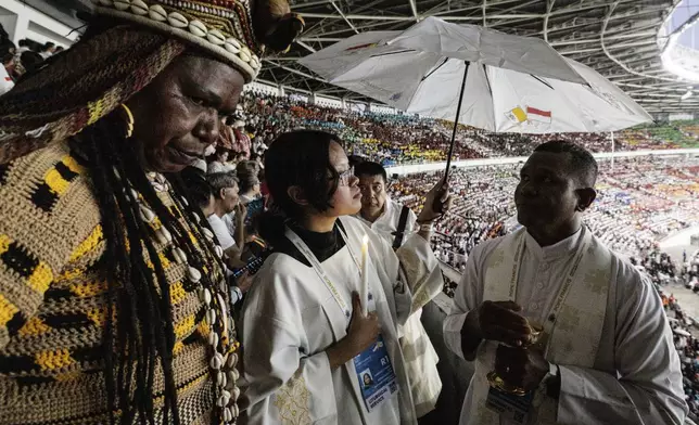 A priest gives Holy Communion to the faithful during a holy mass led by Pope Francis at the Gelora Bung Karno Stadium, in Jakarta, Thursday, Sept. 5, 2024. (Yasuyoshi Chiba/Pool Photo via AP)