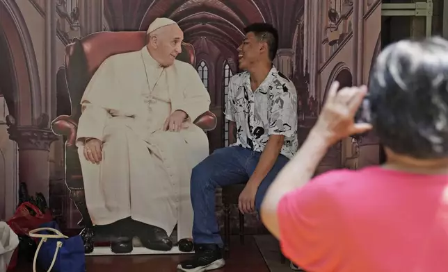 A man has his photo taken with a cutout of Pope Francis displayed at Jakarta Cathedral ahead of his visit to Indonesia from Sept. 3-6, in Jakarta, Indonesia, Sunday, Sept. 1, 2024. (AP Photo/Dita Alangkara)