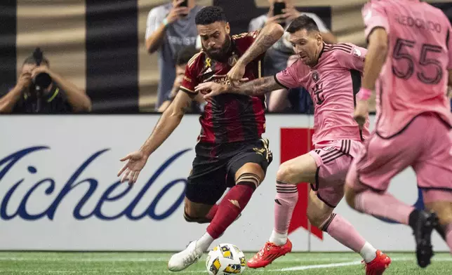 Inter Miami forward Lionel Messi (10), right, and Atlanta United defender Derrick Williams (3) battle for control of the ball during the second half of a MLS soccer match Wednesday, Sept. 18, 2024. (AP Photo/John Bazemore)