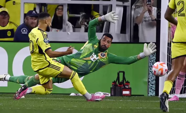 FILE - Inter Miami goalkeeper Drake Callender, center, lunges to block a shot by Nashville SC midfielder Hany Mukhtar, left, during the first half of a CONCACAF Champions Cup tournament soccer match March 7, 2024, in Nashville, Tenn. (AP Photo/Mark Zaleski, File)