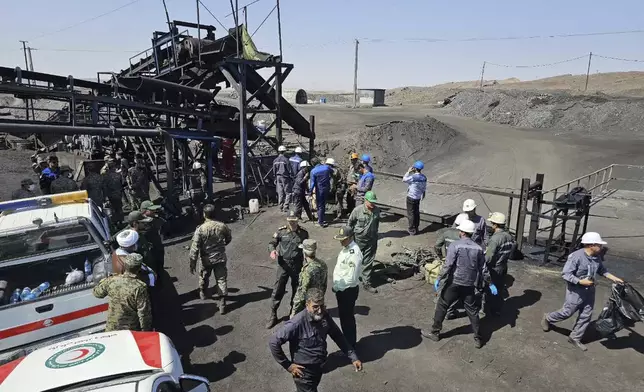 In this photo released by Iranian Red Crescent Society, miners and police officers are seen at the site of a coal mine where methane leak sparked an explosion on Saturday, in Tabas, some 540 kilometers (335 miles) southeastern of the capital, Tehran, Iran, Sunday, Sept. 22, 2024. (Iranian Red Crescent Society, via AP)