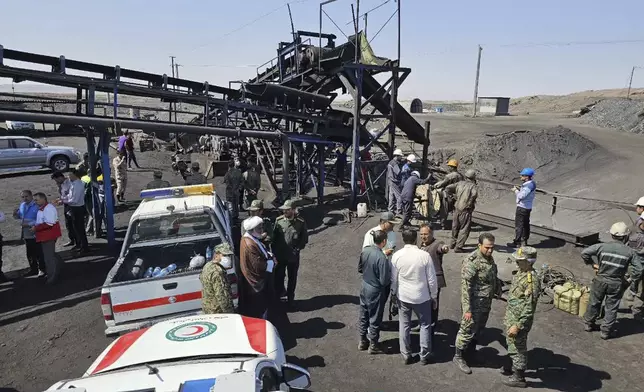 In this photo released by Iranian Red Crescent Society, rescue personnel, police officers and some other people gather around the site of a coal mine where methane leak sparked an explosion on Saturday, in Tabas, some 335 miles (540 kilometers) southeast of the capital Tehran, Iran, Sunday, Sept. 22, 2024. (Iranian Red Crescent Society, via AP)