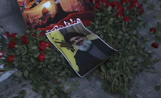 A poster of Hezbollah leader Sayyed Hassan Nasrallah is placed on flowers in front of the Lebanese Embassy in Tehran, Iran, Wednesday, Sept. 18, 2024. (AP Photo/Vahid Salemi)