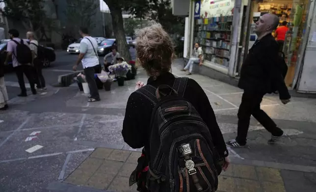 FILE - An Iranian woman, without a mandatory headscarf, or hijab, walks in downtown Tehran, Iran, June 10, 2024. (AP Photo/Vahid Salemi, File)