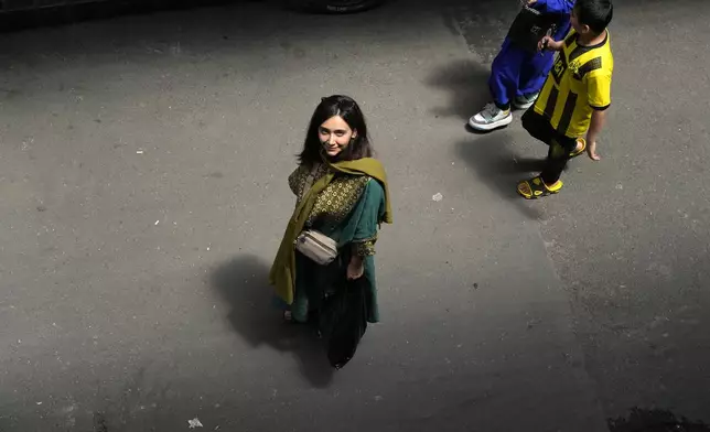 FILE - An Iranian woman without a mandatory headscarf, or hijab, walks at the old main bazaar of Tehran, Iran, June 13, 2024. (AP Photo/Vahid Salemi, File)