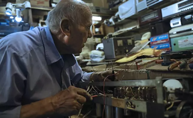 Reza Alimirzaei, 73, who repairs and sells old radios, works at his shop in downtown Tehran, Iran, Wednesday, Sept. 18, 2024. (AP Photo/Vahid Salemi)