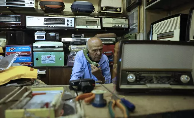 Reza Alimirzaei, 73, who repairs and sells old radios, talks on the phone at his shop in downtown Tehran, Iran, Wednesday, Sept. 18, 2024. (AP Photo/Vahid Salemi)