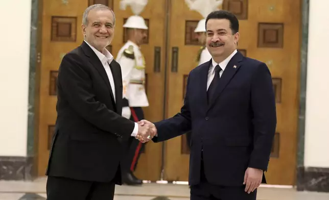 Iranian President Masoud Pezeshkian, left, and Iraqi Prime Minister Mohammed Shia al-Sudani shake hands at the government palace in Baghdad, Iraq, Wednesday, Sept. 11, 2024. (Ahmed Jalil/Pool Photo via AP)