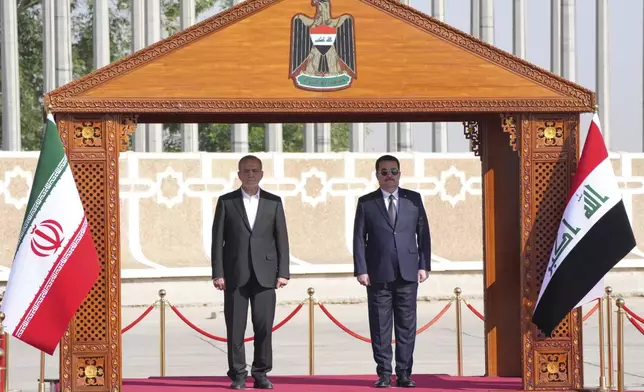 Iranian President Masoud Pezeshkian is welcomed by Iraqi Prime Minister Mohammed Shia al-Sudani, right, with an official ceremony at the Baghdad International Airport in Baghdad, Iraq, Wednesday Sept. 11, 2024. (Murtadha Al-Sudani/Pool Photo via AP)