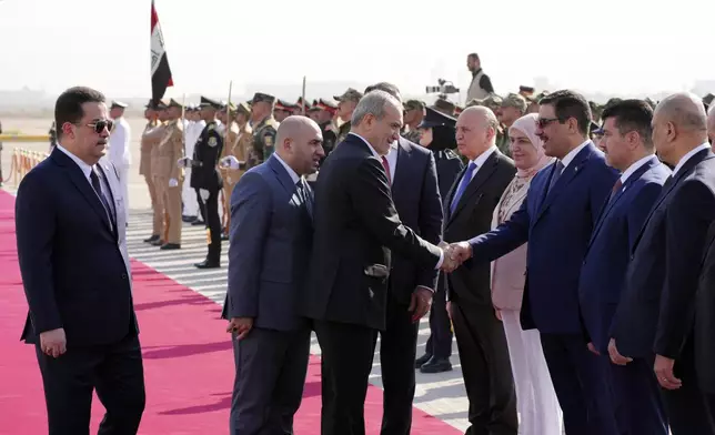 Iranian President Masoud Pezeshkian, center, is welcomed by Iraqi Prime Minister Mohammed Shia al-Sudani, left, with an official ceremony at the Baghdad International Airport in Baghdad, Iraq, Wednesday Sept. 11, 2024. (Murtadha Al-Sudani/Pool Photo via AP)