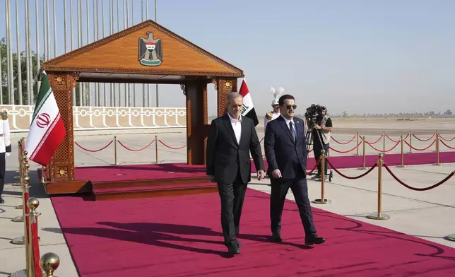 Iranian President Masoud Pezeshkian is welcomed by Iraqi Prime Minister Mohammed Shia al-Sudani, right, with an official ceremony at the Baghdad International Airport in Baghdad, Iraq, Wednesday Sept. 11, 2024. (Murtadha Al-Sudani/Pool Photo via AP)