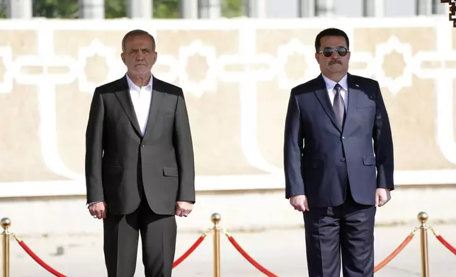 Iranian President Masoud Pezeshkian is welcomed by Iraqi Prime Minister Mohammed Shia al-Sudani, right, with an official ceremony at the Baghdad International Airport in Baghdad, Iraq, Wednesday Sept. 11, 2024. (Murtadha Al-Sudani/Pool Photo via AP)