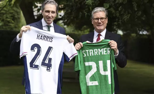 The Prime Minister of Ireland Simon Harris, left, and his British counterpart Keir Starmer hold up their respective national soccer teams shirts, with their names on their opposite teams shirt, at Farmleigh House in Dublin, Ireland, Saturday, Sept. 7, 2024. Ireland and England play a nations league soccer match in Dublin later. (AP Photo/Peter Morrison Pool)