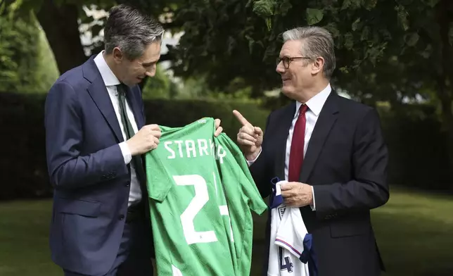 The Prime Minister of Ireland Simon Harris, left and his British counterpart Keir Starmer hold up their respective national soccer teams shirts, with their names on their opposite teams shirt, at Farmleigh House in Dublin, Ireland, Saturday, Sept. 7, 2024. (AP Photo/Peter Morrison Pool)