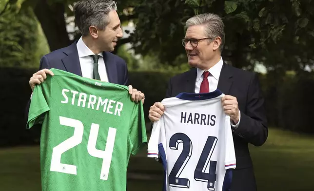 The Prime Minister of Ireland Simon Harris, left, and his British counterpart Keir Starmer hold up their respective national soccer teams shirts, with their names on their opposite teams shirt, at Farmleigh House in Dublin, Ireland, Saturday, Sept. 7, 2024. Ireland and England play a nations league soccer match in Dublin later. (AP Photo/Peter Morrison Pool)