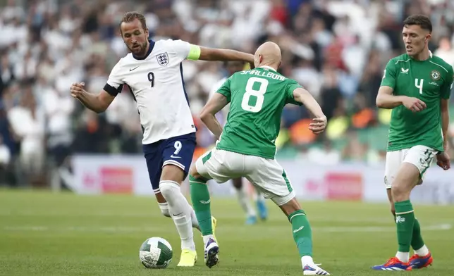 England's Harry Kane, left ,get past the challenge of Ireland's Will Smallbone, during the UEFA Nation's League soccer match between Ireland and England at the Aviva stadium in Dublin, Ireland, Saturday, Sept. 7, 2024. (AP Photo/Peter Morrison)