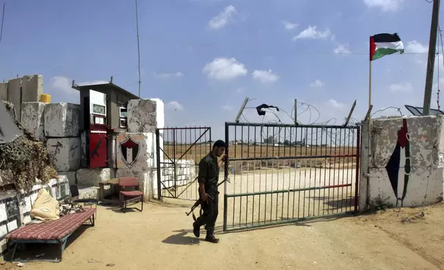 FILE -A Palestinian security officer loyal to Hamas opens a gate to the Philadelphi corridor between Egypt and Gaza near the southern Gaza Strip town of Rafah, July, 1, 2007. (AP Photo/Khalil Hamra, File)