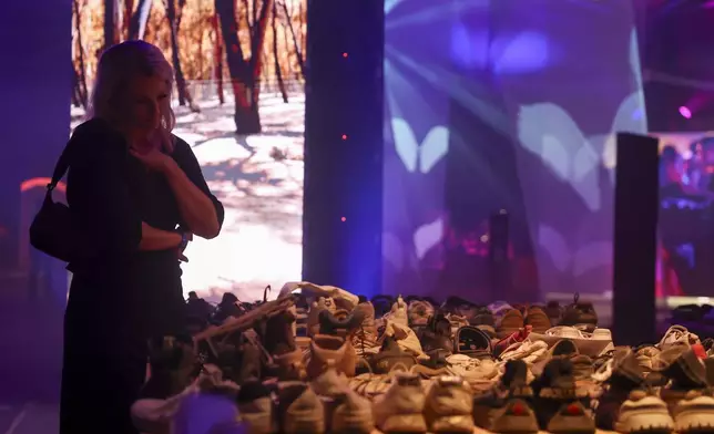 A woman looks at a collection of shoes recovered from the Nova Music Festival after the Oct. 7, 2023, attack by Hamas, after a vigil Sunday, Sept. 1, 2024, in Culver City, Calif., for the six hostages who were found dead in Rafah, southern Gaza. (AP Photo/Ryan Sun)