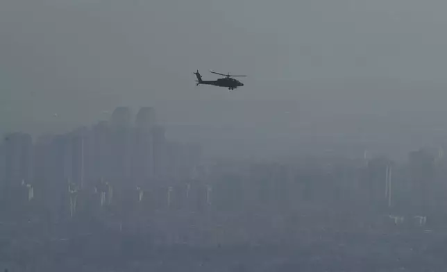 An Israeli Air Force Apache helicopter flies over the Mediterranean Sea near the northern Israeli city of Kiryat Yam, Saturday, Sept. 28, 2024. (AP Photo/Baz Ratner)