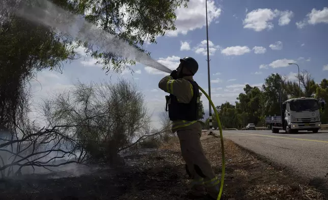 An Israeli firefighter works to extinguish a fire burning in an area, following an attack from Lebanon, near the Kibbutz Snir, northern Israel, Monday, Sept. 16, 2024. (AP Photo/Leo Correa)