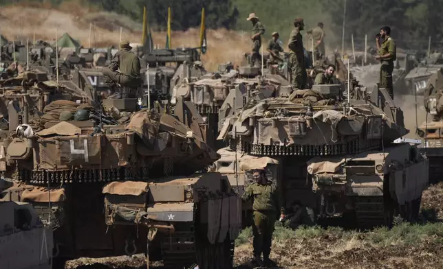 Israeli soldiers work on tanks in northern Israel on Friday, Sept. 27, 2024. (AP Photo/Baz Ratner)