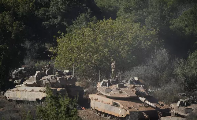 Israeli soldiers work on tanks in northern Israel on Friday, Sept. 27, 2024. (AP Photo/Baz Ratner)