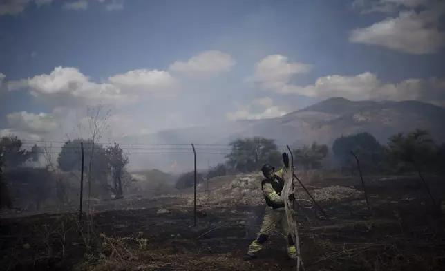 An Israeli firefighter works to extinguish a fire burning in an area, following an attack from Lebanon, near the Kibbutz Snir, northern Israel, Monday, Sept. 16, 2024. (AP Photo/Leo Correa)