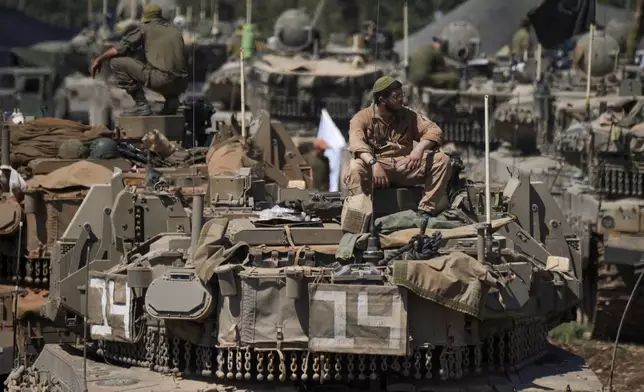 Israeli soldiers work on tanks in northern Israel on Friday, Sept. 27, 2024. (AP Photo/Baz Ratner)