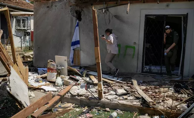 People look at a damaged house that was hit by a rocket fired from Lebanon, near Safed, northern Israel, on Wednesday, Sept. 25, 2024. (AP Photo//Leo Correa)