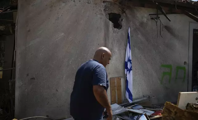 A man looks at a damaged house that was hit by a rocket fired from Lebanon, near Safed, northern Israel, on Wednesday, Sept. 25, 2024. (AP Photo//Leo Correa)